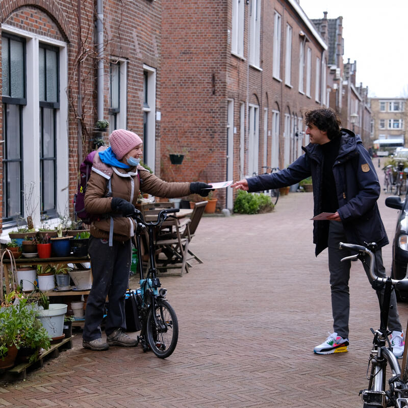 Jesse deelt een folder uit op campagne
